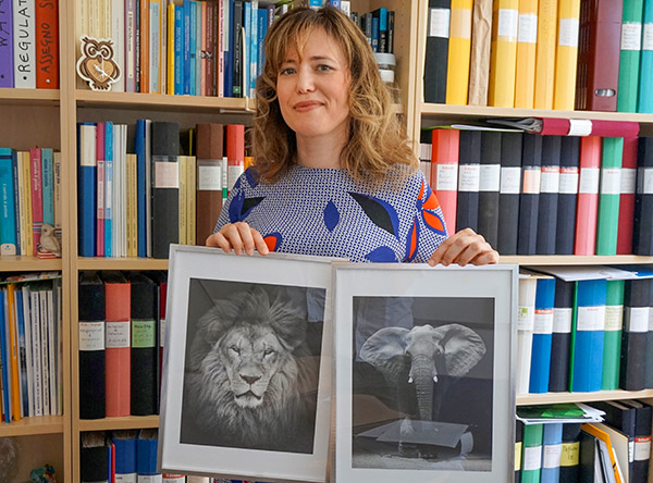 Daniela Argento med tavlor på ett lejon och en elefant.