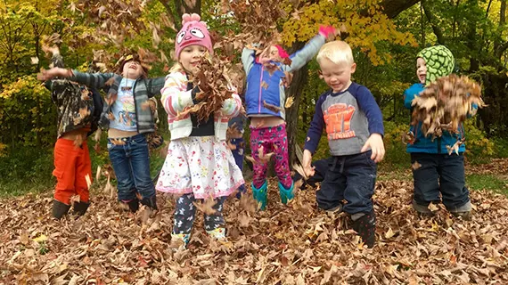 Barn som leker med löv på en förskola. Barn som leker med löv på en förskola.