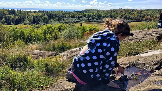 Barn leker med pinne på klipphäll. Barn leker med pinne på klipphäll.