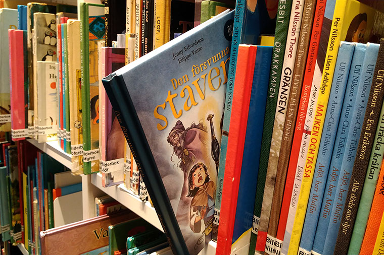 Biblioteksbokhylla med Den försvunna staven utdragen.