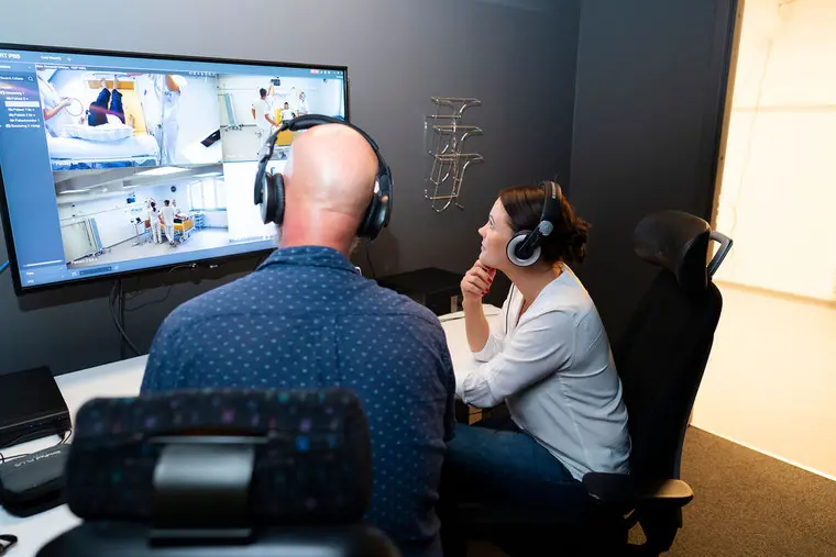 Tv&aring; l&auml;rare tittar p&aring; simulerings&ouml;vning p&aring; en tv-sk&auml;rm.