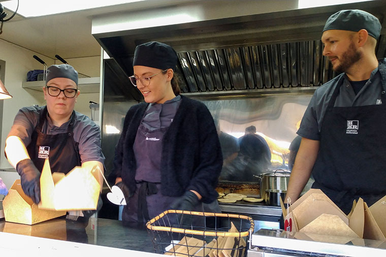 Thora Hjartardóttir, Nicole Millward och Adam Strömgren langar lunchlådor ur foodtrucken.