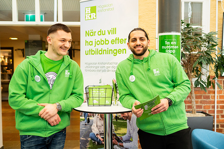 Två studenter i gröna tröjor på Högskolan Kristianstad
