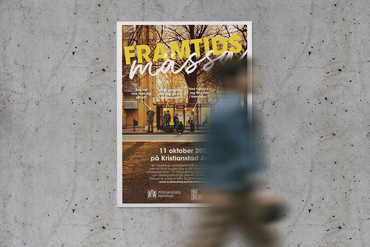 Person går förbi betongvägg med Framtidsveckanposter.