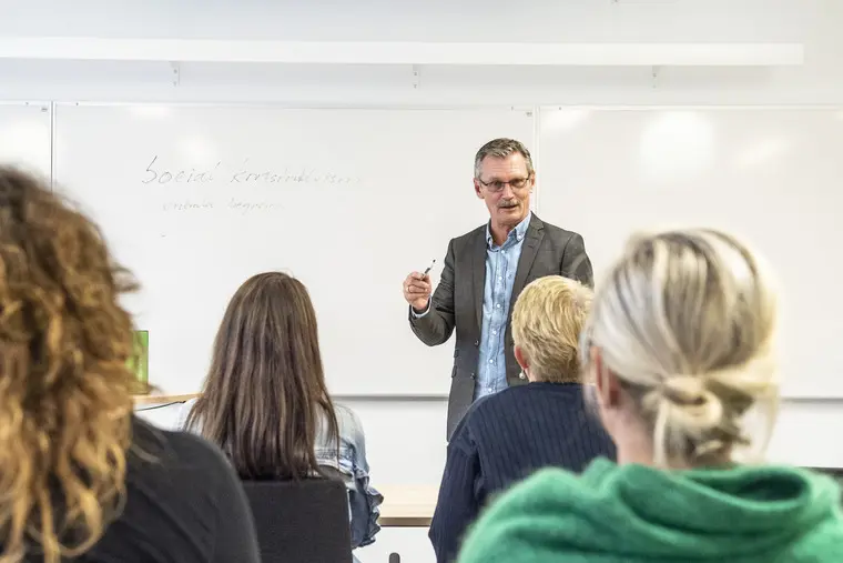 Lärare undervisar i klassrum.
