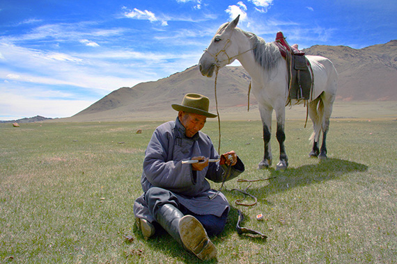 Hästburen herde med pipa, Kovd Aimag, i västra Mongoliet.