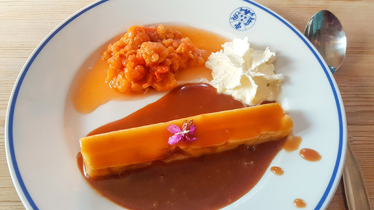 I fjällstationens restaurang får vi smaka på Laponia. Här en efterrätt på kaffeost med hjortron, vispgrädde och kola, med en liten rosa blomma från mjölkört, eller rallarros som den också kallas. Foto: Johanna Grönroos