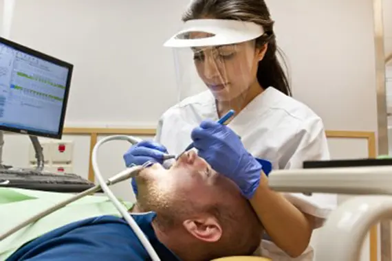 Tandhygienist behandlar patient.