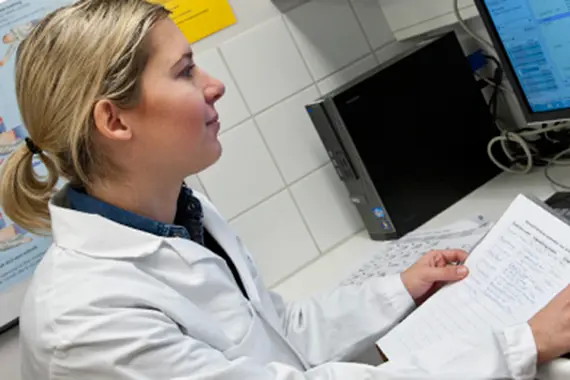 Tandhygienist vid dator.