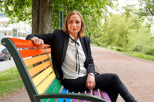 Eva Schömer på en regnbågsfärgad parkbänk.
