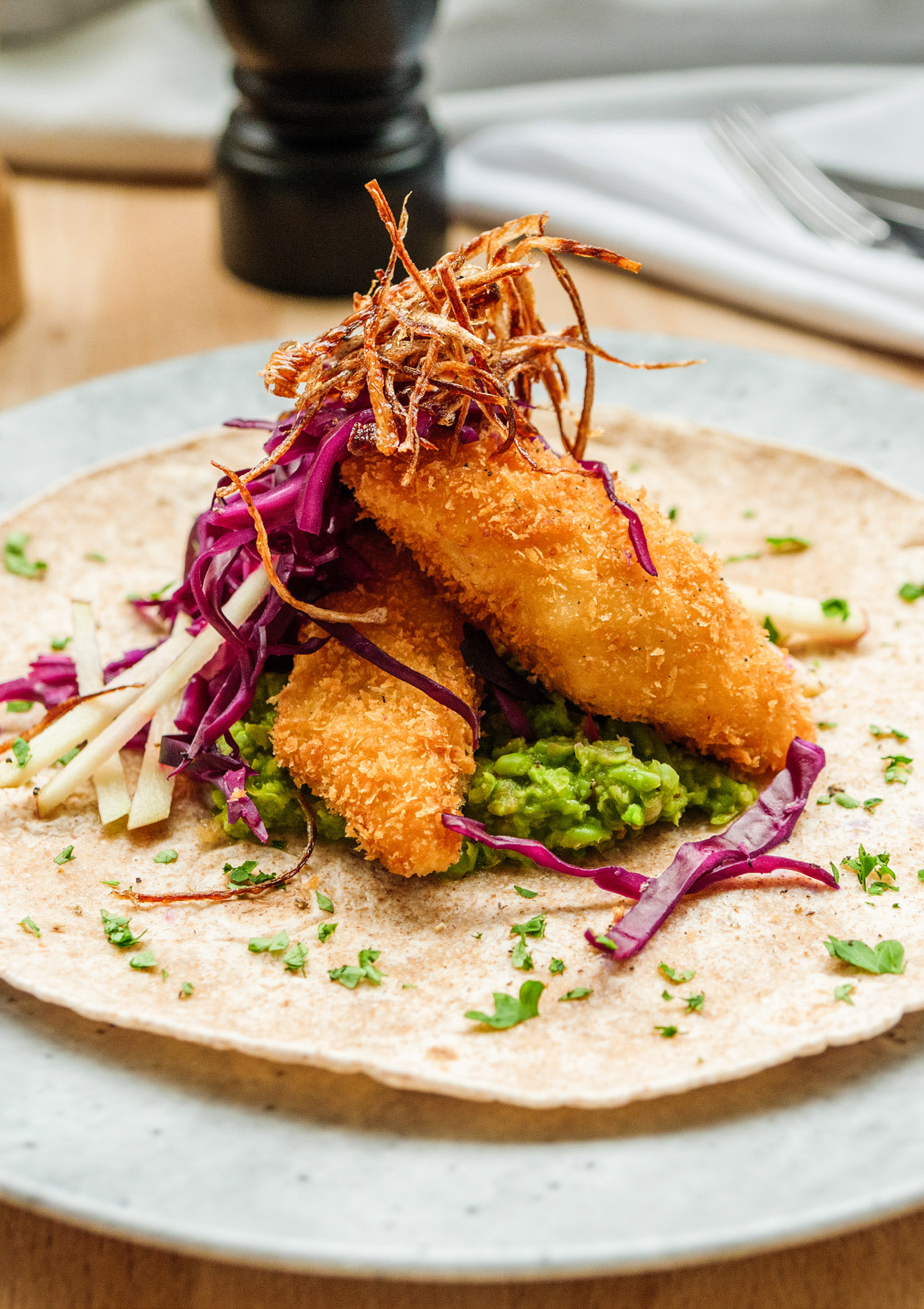 Taco med pankofriterad braxen, ärtguacamole, syrad rödkål, äpple och friterad schalottenlök.