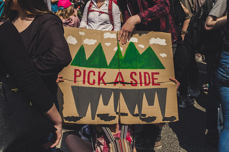 Demonstranter med plakat med texten Pick a side!