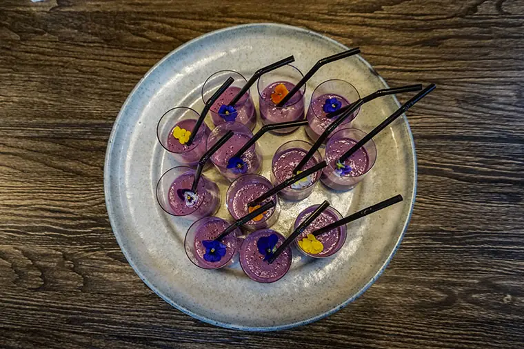 Bl&aring;b&auml;rssmootie i glass p&aring; bricka. Smoothien &auml;r inte bara dekorativ. Den har spetsats med kvarg och vassleprotein f&ouml;r att ge extra protein &aring;t &auml;ldre m&auml;nniskor med motoriska &auml;tsv&aring;righeter.