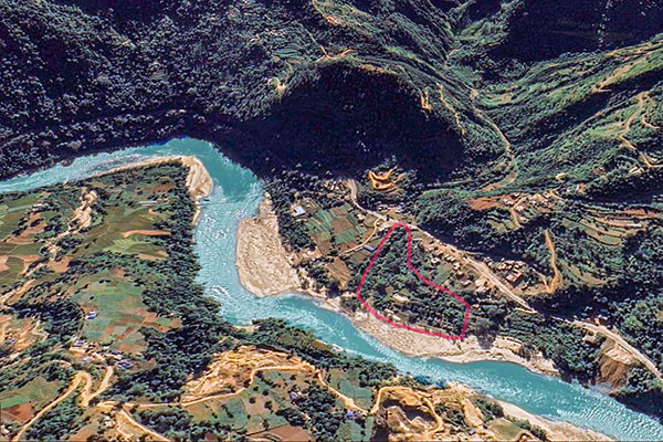 Floden Trishuli får sin turkosa färg från Himalayas smältande glaciärer i norr. Där den meandrar sig fram genom landskapet bildas vita sandbankar, som här i Katauti Khola, där Summit IL Academy äger 1,2 hektar mark.