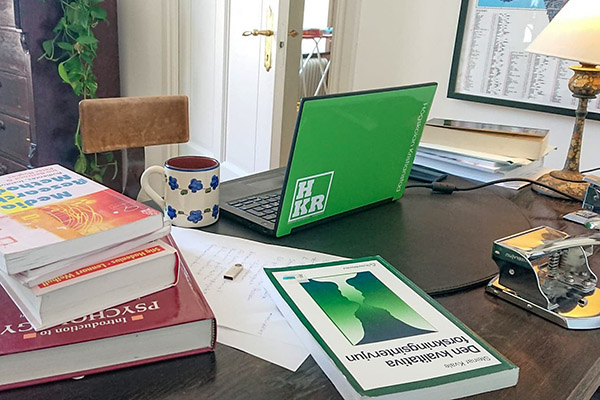 Distansstudier med kurslitteratur och laptop på skrivbord.