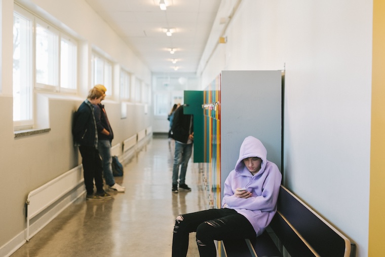 Fyra ungdomar i en skolkorridor.