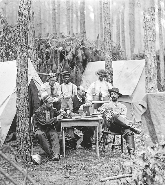 Officerare ur 114. Pennsylvania infantry spelar kort i ett fältläger. Förbandet är från unionssidan och de färgade är anställda tjänare ... (ur Amerikanska inbördeskriget, s. 10)