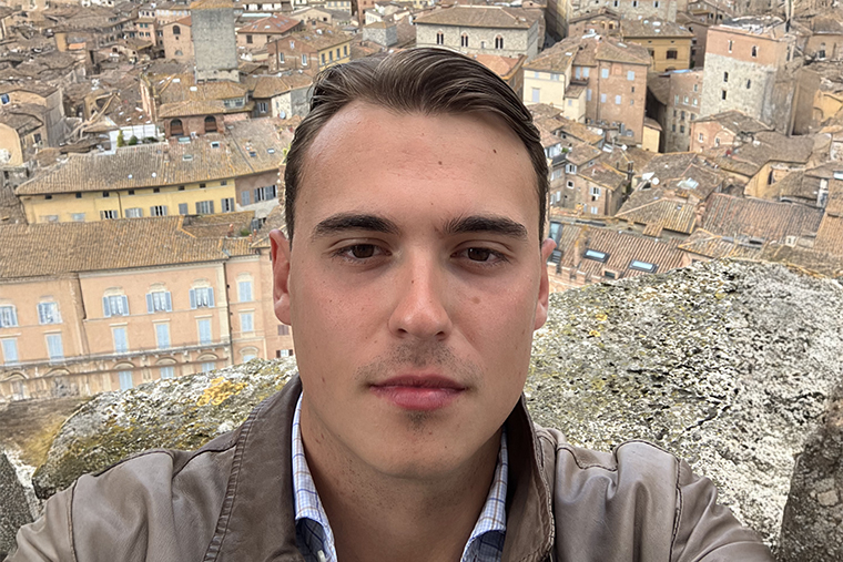 Oscar i närbild med italiensk stad i bakgrunden