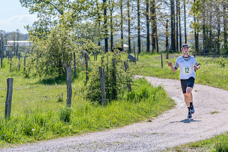 En löpare på en grusväg i skogen.