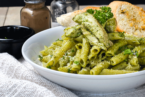 En tallrik med pasta och grön pesto.