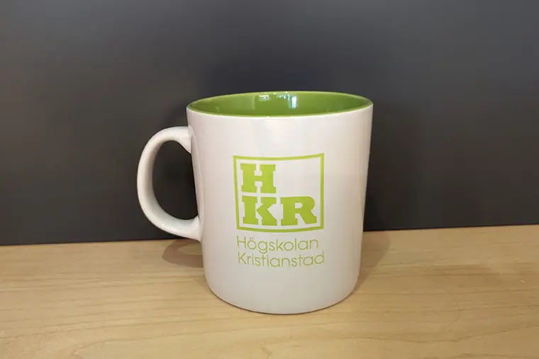 Coffee mug, white with green HKR logo and green inside.
