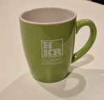 grön mugg med högskolan kristianstads logga