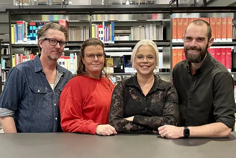 Four people in a libary.