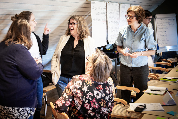 Fem kvinnor i glatt samtal under utbildning