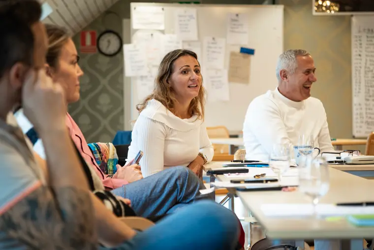 Deltagare i workshop vid bord med anteckningar i bakgrunden.