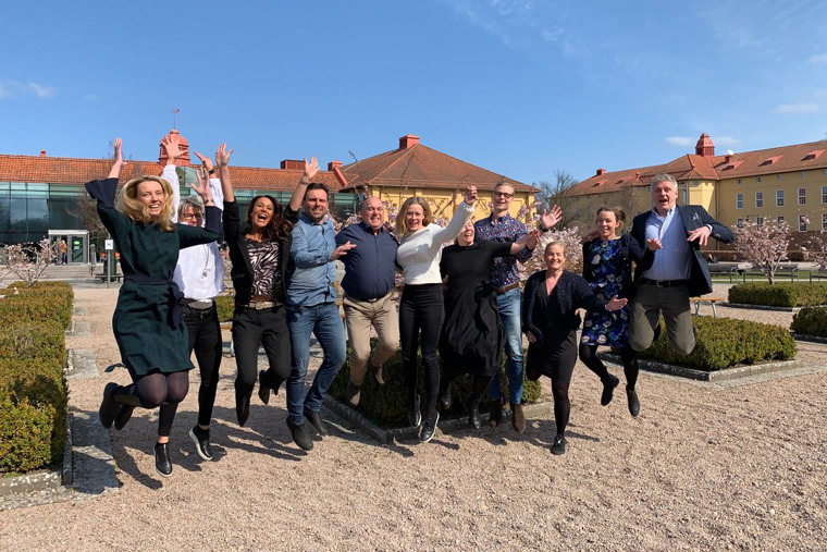 Glada deltagare på högskolans campus.