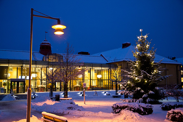 Högskolan Kristianstad utomhus på vinter, snö och julgran.