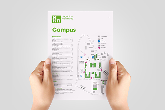 Två händer håller en karta över campus