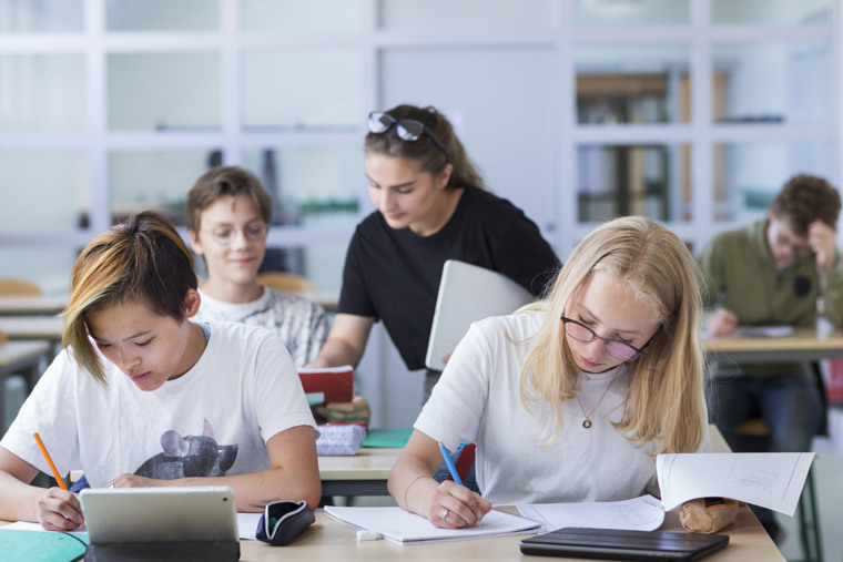 Elever i klassrum engagerade i skolarbete.
