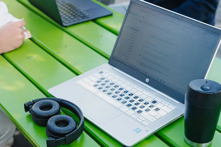 Dator på ett grönt bord.