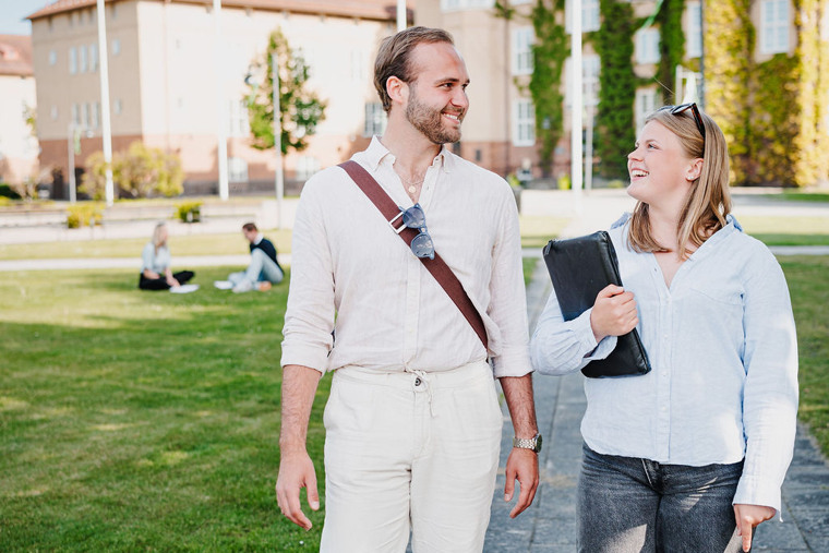 En man och en kvinna g&aring;r utomhus.
