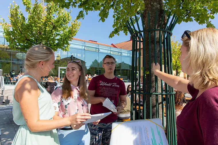Studenter utomhus på högskolans campus.