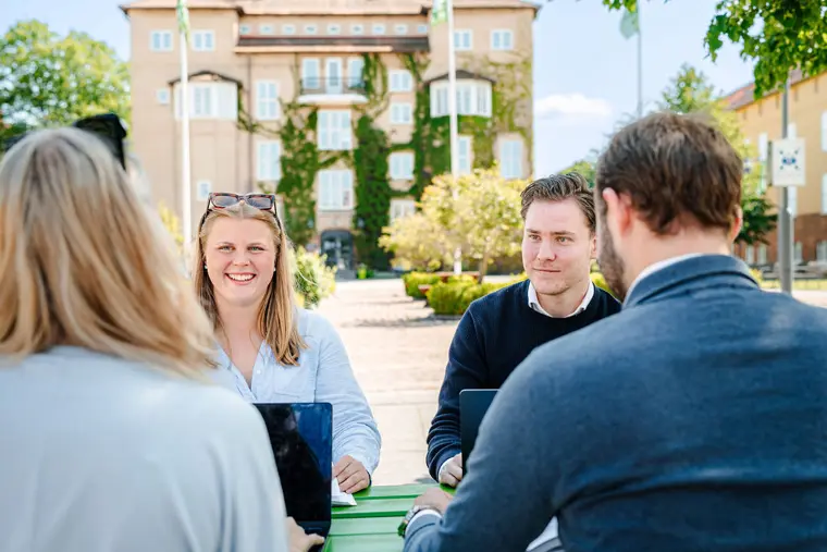 Studenter utomhus p&aring; h&ouml;gskolans campus.