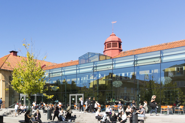 En grupp m&auml;nniskor som sitter utanf&ouml;r en byggnad.