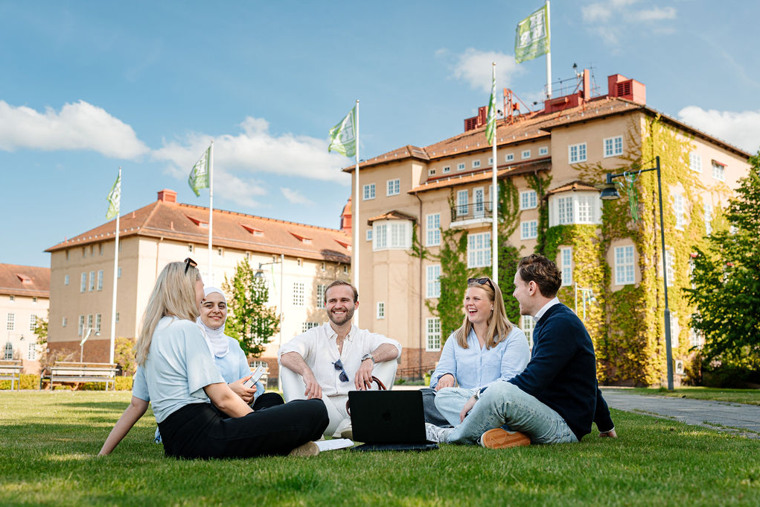 En grupp människor som sitter på gräsmatta.